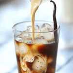 To make a great Vanilla Bean Cold Brew, you need three key items: - Coarsely ground coffee: This is the heart of your brew. It gives the drink its rich flavor. - Cold water: Using cold water helps extract the best taste from the coffee over time. - Vanilla bean: This adds a sweet and creamy flavor. It makes your cold brew special. You can take your Vanilla Bean Cold Brew to the next level with these extras: - Milk: You can use whole, almond, or oat milk. Any choice will add creaminess. - Sweetened condensed milk: This is perfect for those who enjoy a sweeter drink. - Ice cubes: These keep your drink cold and refreshing. - Garnish options: An extra vanilla bean pod can make your drink look fancy. For the full recipe, check out the Vanilla Dream Cold Brew . Enjoy your drink! Start by making your cold brew base. In a large jar or pitcher, mix: - 1 cup coarsely ground coffee - 4 cups cold water Stir gently to combine. Make sure all the coffee grounds get wet. This step is key for rich flavor. Next, add the vanilla bean. Split it open and scrape the seeds into the mix. This helps the vanilla flavor seep into the coffee. Now, cover the jar or pitcher. Refrigerate it for 12 to 24 hours. The longer you let it sit, the stronger the flavor becomes. This infusion time is what brings out the deep vanilla notes. After brewing, it’s time to strain. Use a fine mesh sieve or a coffee filter. This will catch the coffee grounds and vanilla pod. Pour the strained coffee into a clean pitcher. To serve, fill a glass with ice cubes. Pour the cold brew over the ice. Add milk to your taste, whether you like whole, almond, or oat milk. For a sweeter touch, consider mixing in sweetened condensed milk. Finally, garnish your drink with a slice of the extra vanilla bean pod for a nice look. Enjoy your refreshing Vanilla Bean Cold Brew! For the best flavor, I suggest brewing your cold brew for 12 to 24 hours. If you like a stronger taste, try brewing it longer. For a milder flavor, brew it on the shorter end. Always taste your brew to see what you like best. To make your cold brew even better, consider using different sweeteners. Honey, agave, or maple syrup all work well. You can also add spices like cinnamon for a warm twist. For coffee beans, pick high-quality, fresh beans. They make a big difference in taste. To get a creamy texture, froth your milk before adding it to your cold brew. You can use a frother or a jar to shake your milk until it’s frothy. When serving, use ice cubes that won’t melt fast. Ice cubes made from coffee or milk work great. They keep your drink cool without watering it down. Follow these tips for a refreshing Vanilla Bean Cold Brew every time. Enjoy the rich flavors and creamy texture that this drink brings. If you want the full details on making this drink, check out the Full Recipe. {{image_2}} You can enjoy your vanilla bean cold brew in many ways. One fun way is by adding flavor extracts like caramel or hazelnut. Just a few drops can change your drink's taste. You can also add spices like cinnamon or nutmeg. These spices add warmth and depth. Try mixing them in with your vanilla for a cozy twist. If you prefer non-dairy options, you have many choices. Almond, oat, or coconut milk works well in cold brew. They add creaminess without dairy. For sweetening, consider sugar-free options like stevia or monk fruit. These sweeteners keep your drink light and tasty. You can serve vanilla bean cold brew hot or blended. To enjoy it hot, just heat up your cold brew. If you want a frosty drink, blend it with ice for a smoothie-like texture. You can also use other brewing methods, like a French press. This method gives you a rich flavor too. For the complete recipe, check out the Full Recipe section. Enjoy experimenting with these variations! Store your vanilla bean cold brew in a clean jar or pitcher. Keep it tightly covered to avoid strange flavors. It stays fresh in the fridge for about 5-7 days. After that, the taste may fade. Always check for any off smells or changes in color to ensure it’s still good. You can freeze cold brew for later use. Pour it into ice cube trays for easy storage. Once frozen, transfer the cubes to a freezer bag. This way, you can add cold brew ice cubes to your drinks. To thaw, place them in the fridge overnight. You can also use a microwave, but be careful not to overheat. This method keeps the flavor intact. Don't toss out your coffee grounds! They make great compost for your plants. You can also use them to scrub pots and pans. As for spent vanilla beans, don’t waste them either! You can chop them up and add them to baked goods for extra flavor. They also work well in homemade vanilla extract. Vanilla bean cold brew is a smooth coffee drink. It uses cold water to brew coffee grounds and adds real vanilla for flavor. The main difference from regular cold brew is the vanilla bean. This gives it a rich, sweet taste. Regular cold brew is just coffee and water. The vanilla bean adds a unique twist and elevates the drink's flavor. Making vanilla bean cold brew at home is easy and fun. You need just a few steps. First, mix coarsely ground coffee with cold water in a large jar. Add the split vanilla bean and its seeds to infuse flavor. Cover the jar and let it sit in the fridge for 12 to 24 hours. After brewing, strain the mixture to remove the coffee grounds. Finally, serve it over ice and add milk or sweetener if you like. For the full recipe, check the section above. You can find premade vanilla bean cold brew in many stores. Popular brands include Starbucks and Stumptown. They offer tasty options in ready-to-drink bottles. Each brand has its unique flavor. Some are sweeter, while others are more robust. Check the labels to find the one you like best. Yes, you can easily change the sweetness of your cold brew. If you prefer it sweet, you can add sweetened condensed milk. You can also use sugar, honey, or flavored syrups. Start with a small amount and taste as you go. This way, you’ll find the right balance for your drink. Making Vanilla Bean Cold Brew is fun and easy. You learned the key ingredients, from coarsely ground coffee to the vanilla bean. I shared steps for preparation, brewing, and serving. You now know tips for perfecting your drink and how to try different flavors. Remember to store it right for the best taste. This way, you'll enjoy your cold brew longer. Get creative with your cold brew recipes and enjoy every sip!
